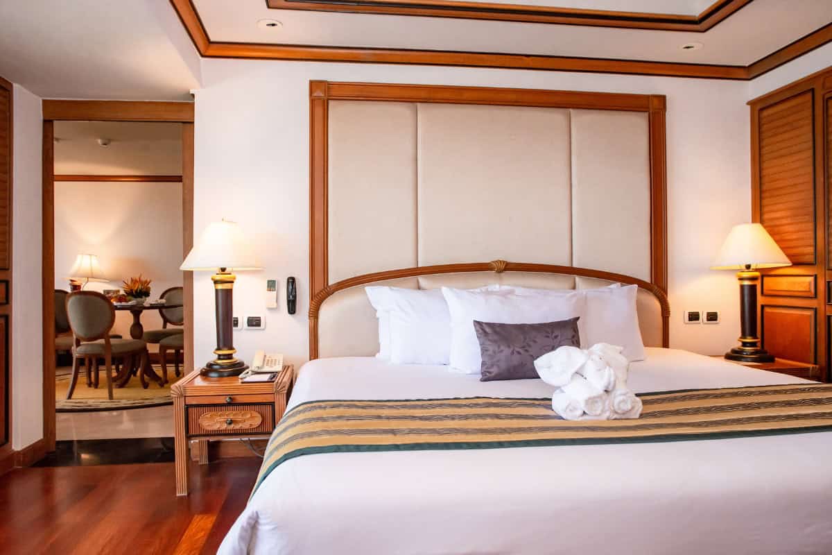 king sized bed with silk runner and origami towel elephant