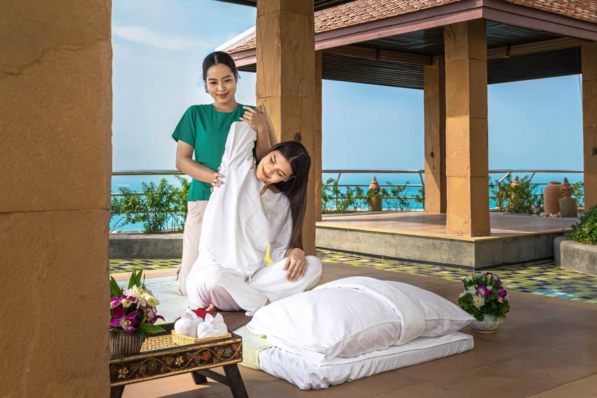 person getting a massage on open terrace overlooking the ocean at spa in pattaya