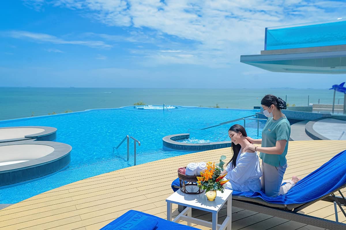 woman getting massage by hotel pool during a wellness tourism retreat